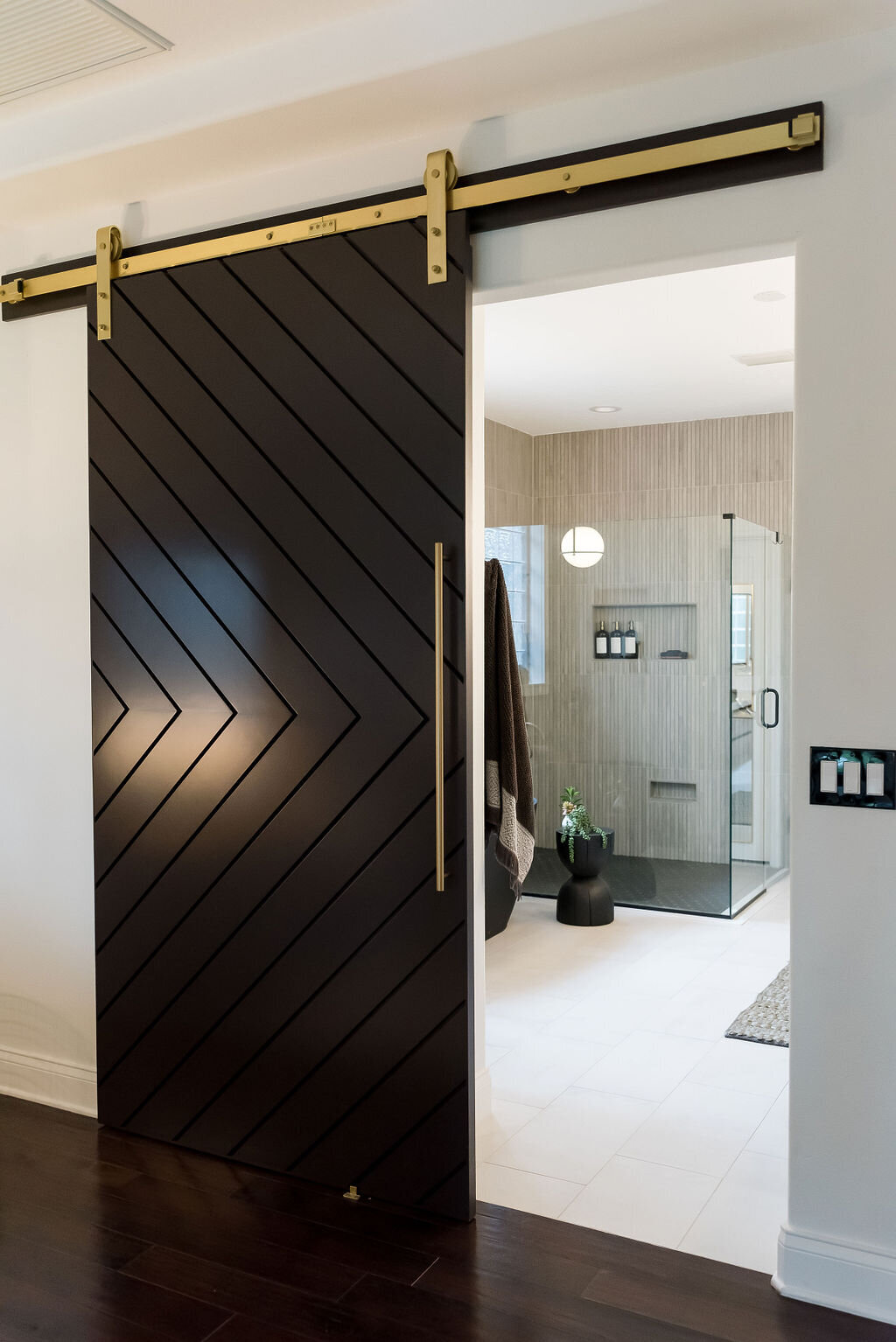 dewine design interiors hotel lux black barn door to bathroom with gold finishings