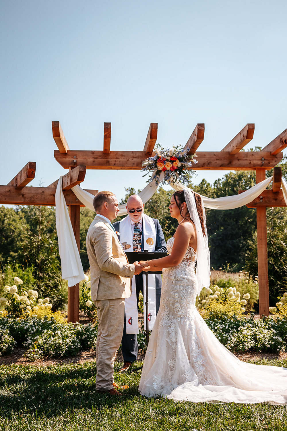 Wedding ceremony at the pergola with floral arrangement and draped fabric