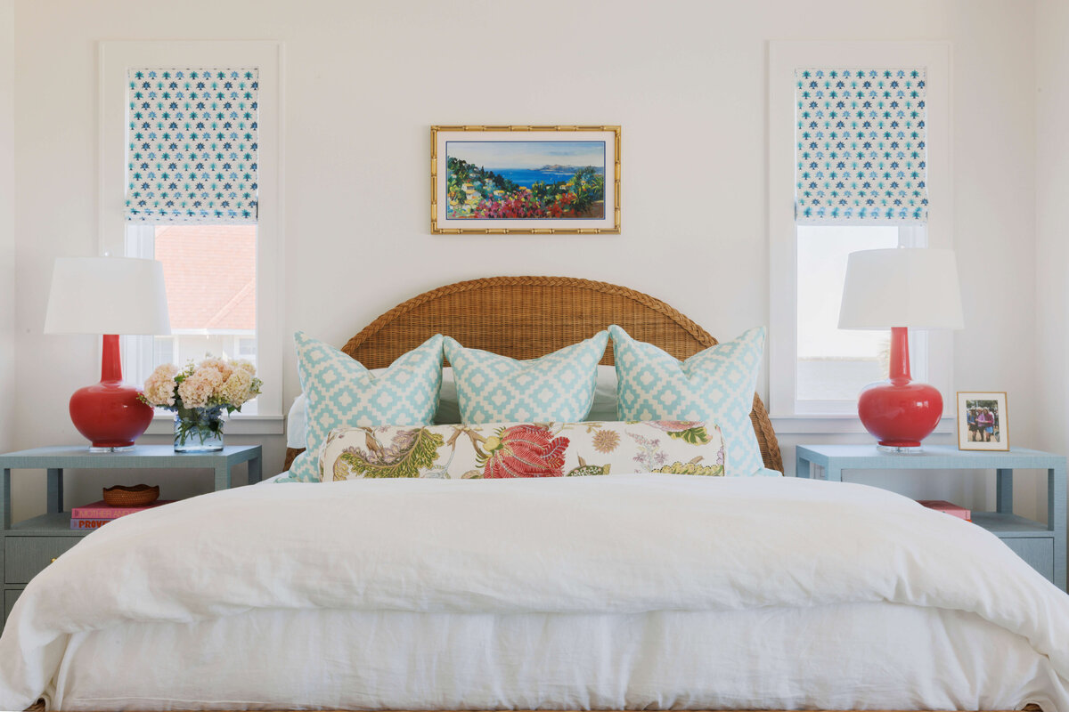 oyster creek studios lighthouse on the lake white bed with light blue pillows and red accent lamps in bedroom