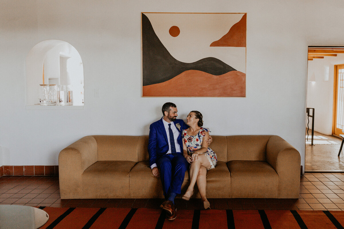bride and groom siting on a retro couch at El Rey Court in Santa Fe