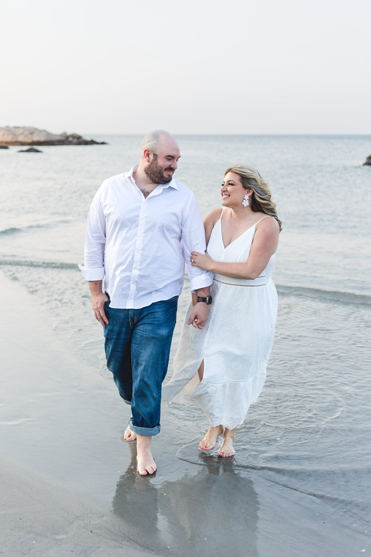 A couple in all white at a beach on the North shore