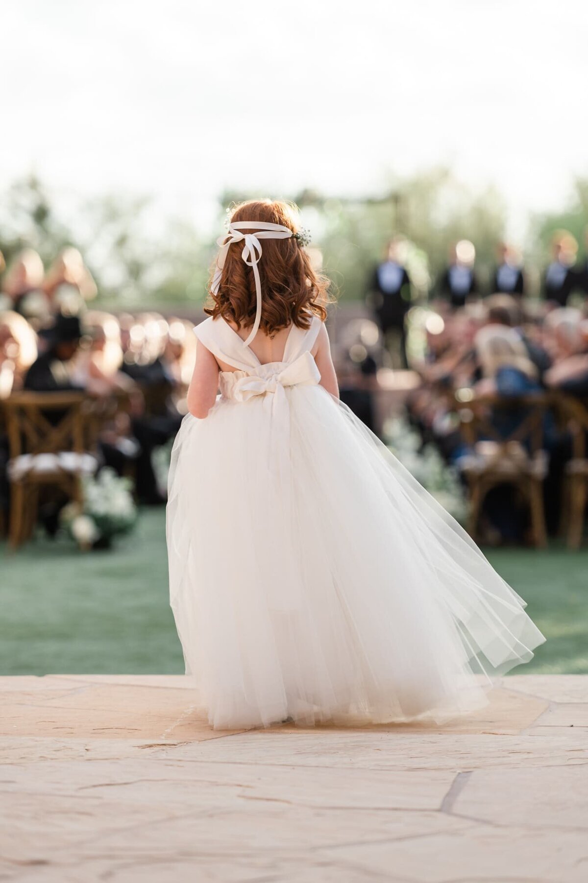 Back view of flower girl about to walk down aisle at Four Seasons at Troon North