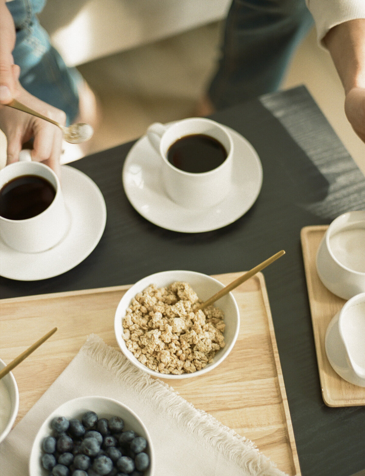 breakfast tray with granola, coffee, hands reaching by film branding photographer in Michigan Christina Harrison