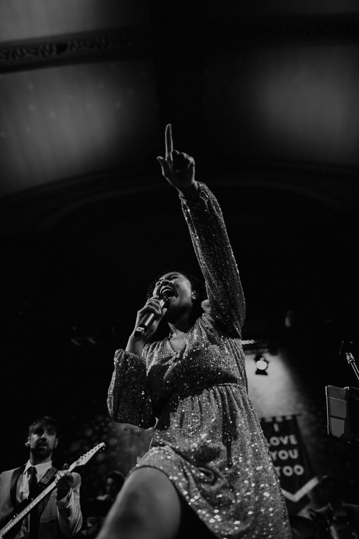 A singer of a band points to the crowd at a wedding at Wilton's Music Hall. 