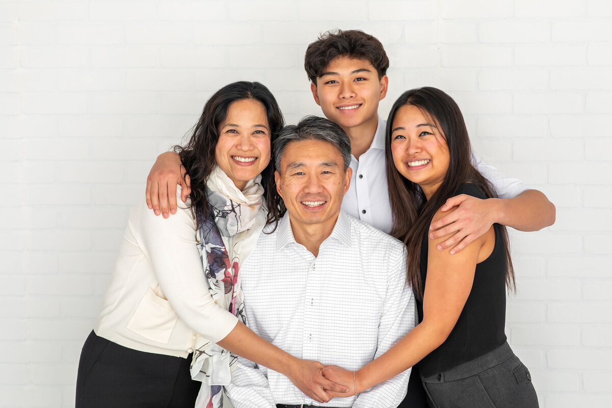 Family of four with older children smiling together during an Ivory Tree Portraits session in Bucks County