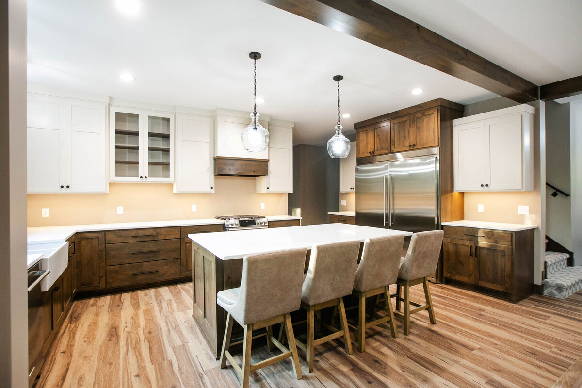 Open kitchen with dark cabinets, large island, and quartz countertops in an Big Lake Township custom home