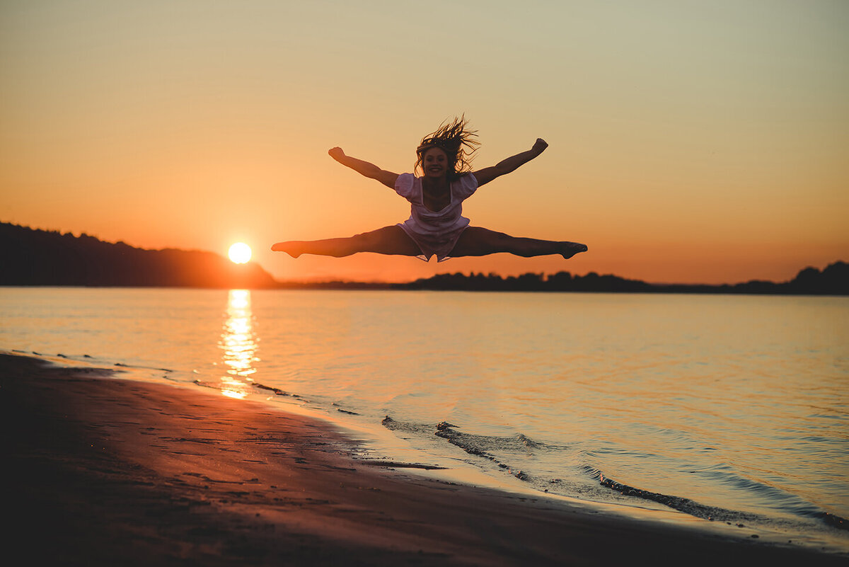 girl jumping at sunset