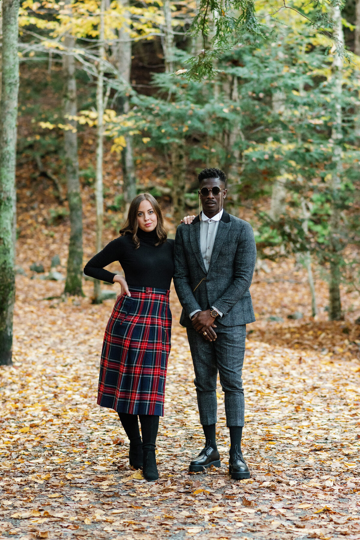 Stylish couple walking through the forest during fall in Nova Scotia.