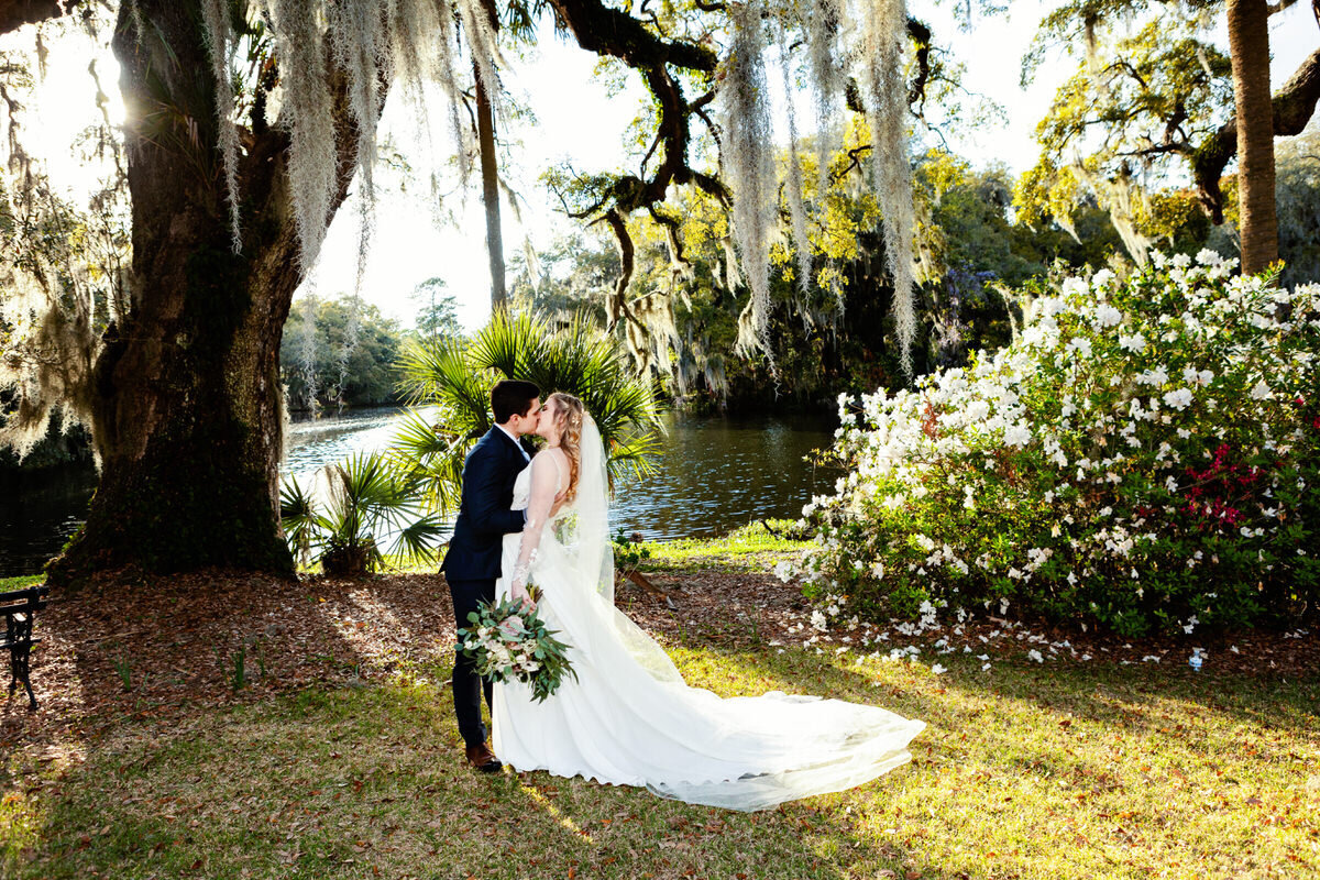 Charleston Wedding Photographer Bride and groom kiss by the water at Legare Waring House
