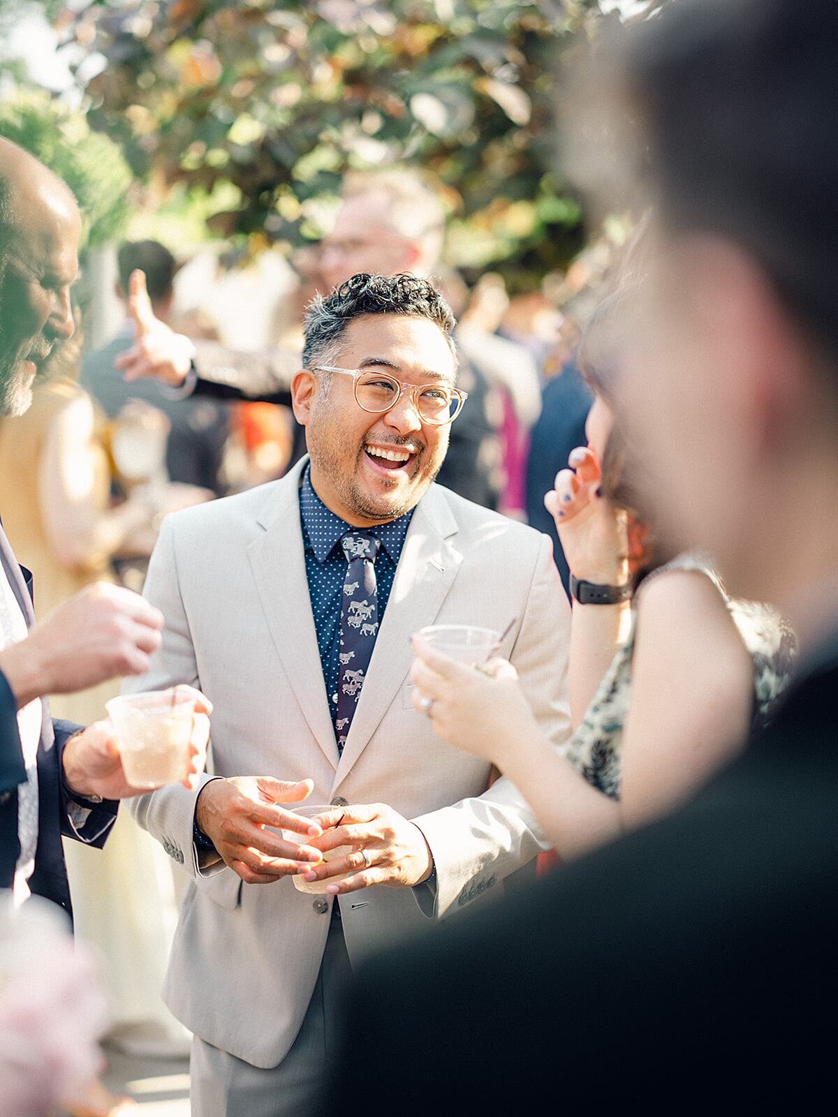 Fashionable wedding guests enjoy signature cocktails in the ivy covered courtyard of Clementine Hall