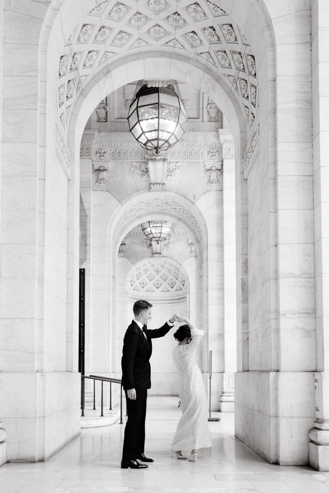 The bride and the groom are dancing in the hallway of the New York Public Library, NYC. Image by Jenny Fu Studio