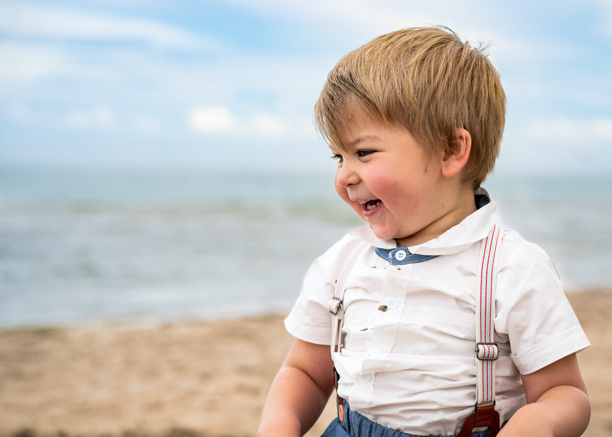 Beach with little happy boy in cute outfit