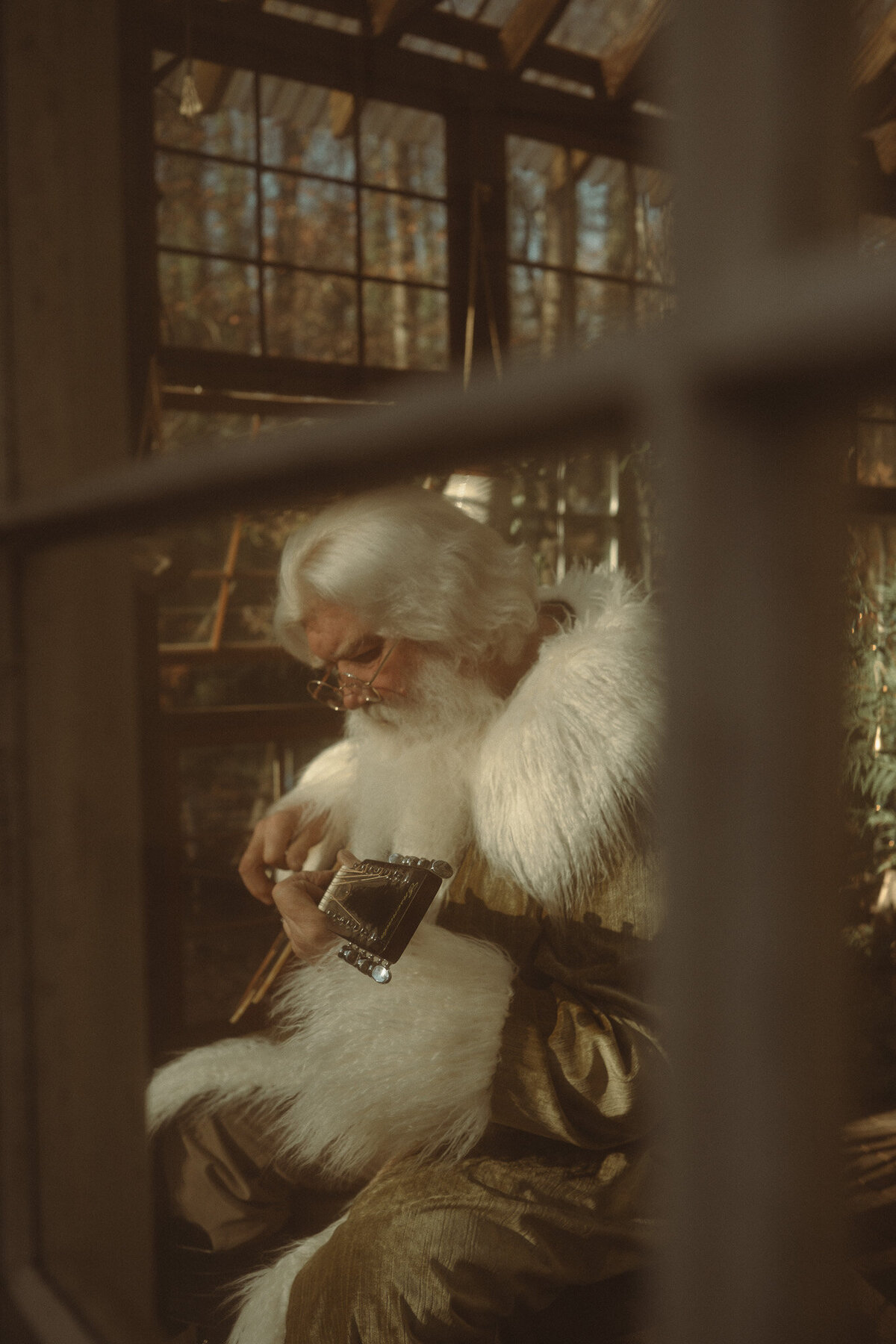 Father Christmas playing the guitar in a glass shack. 