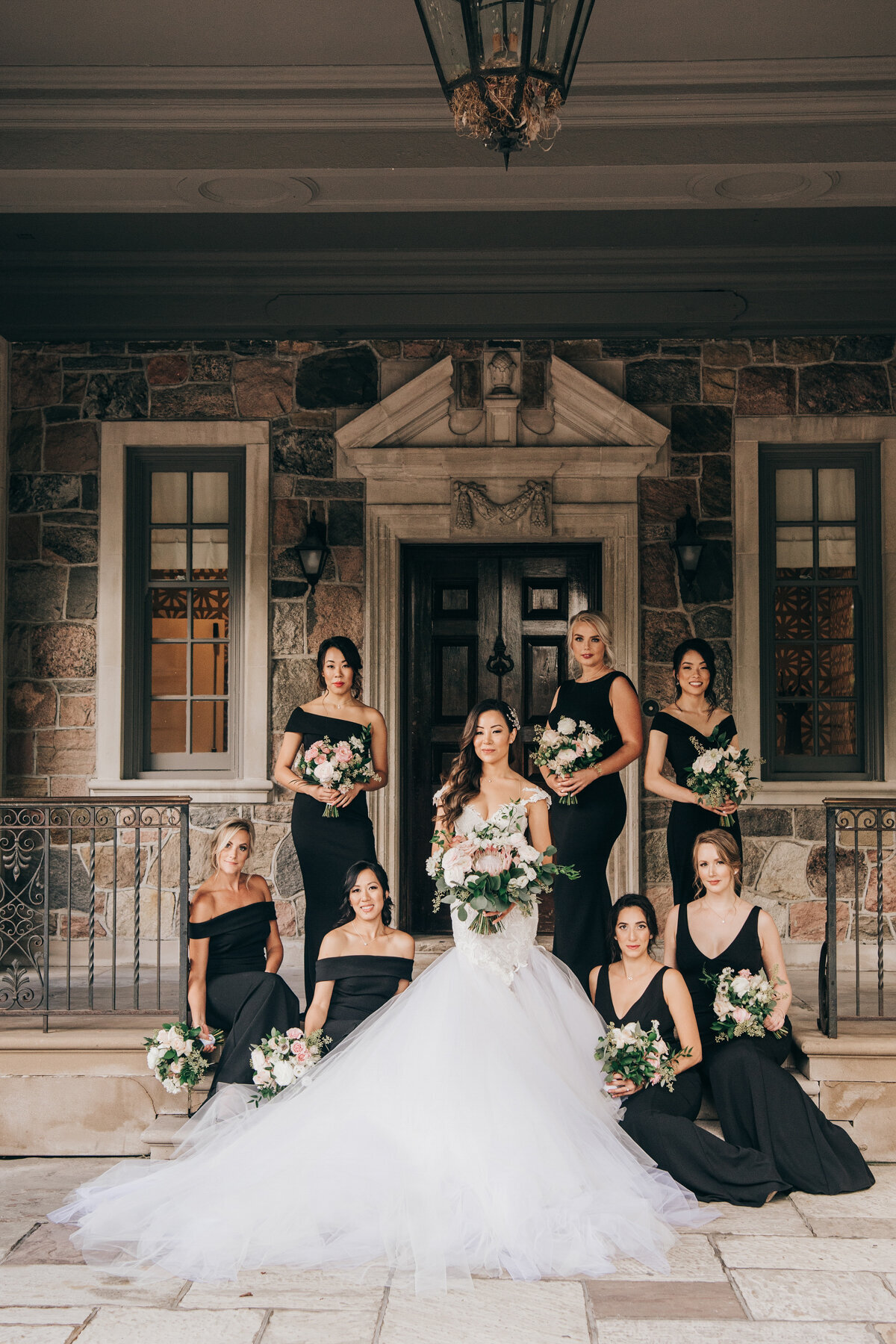 Luxurious bride and bridesmaids portraits holding white and pink florals