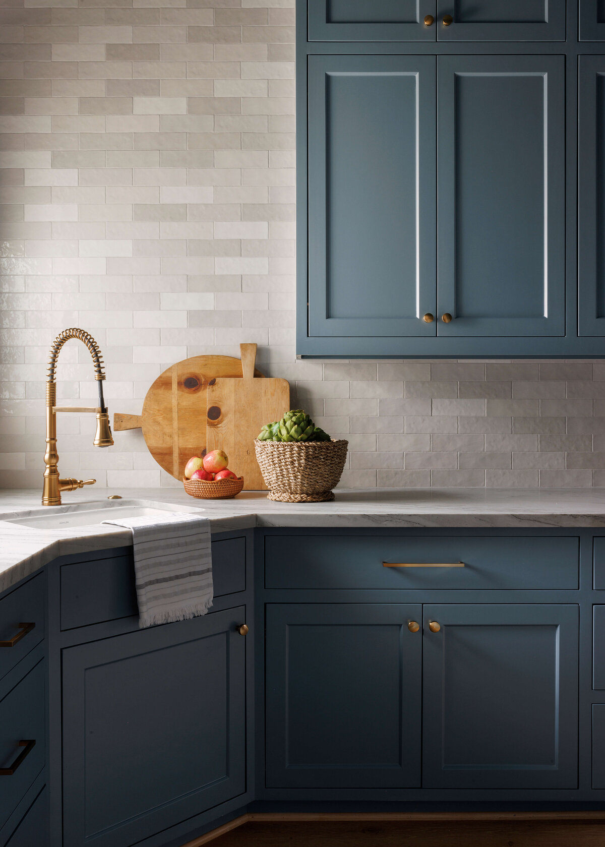 oyster creek studios missouri city new build gold kitchen sink and dark blue counters gray tile wall in kitchen