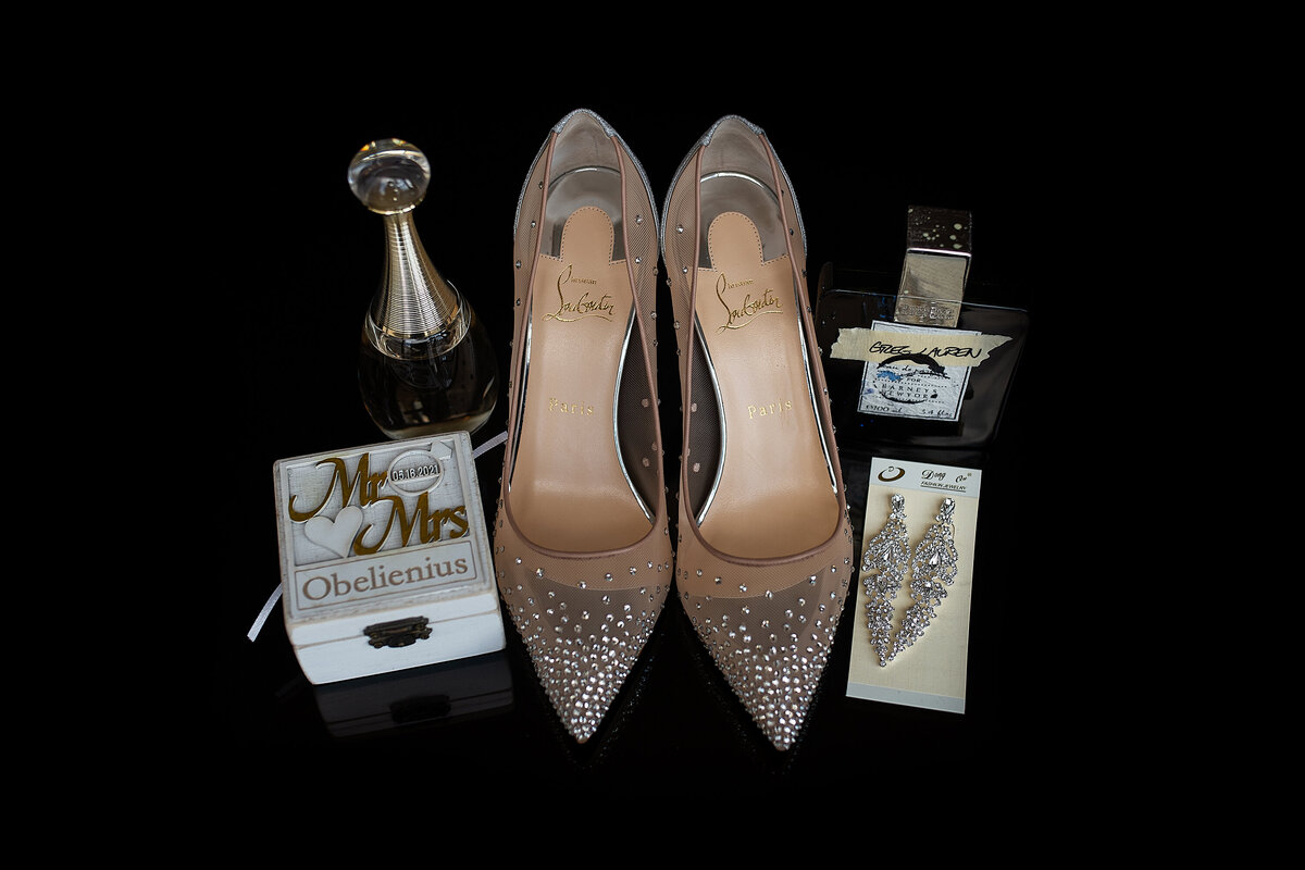 Wedding detail picture of shiny glitter shoes with rings, earrings and expensive perfume