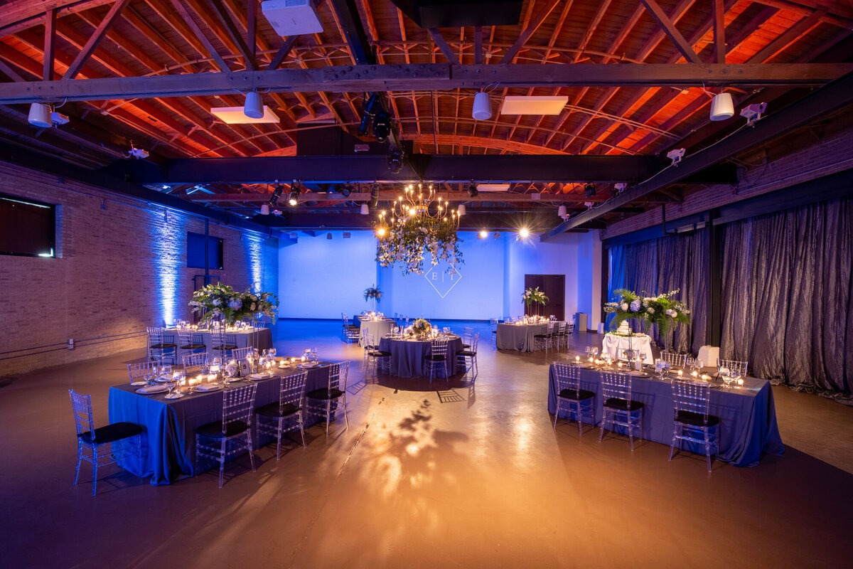A large room with tables and chairs set up for a wedding reception.