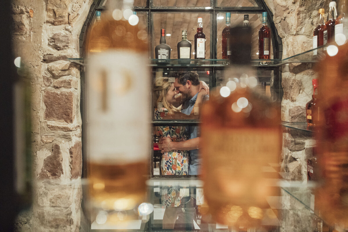 Couple hugging in liquor cellar during engagement session at Logan Inn in New Hope Pennsylvania