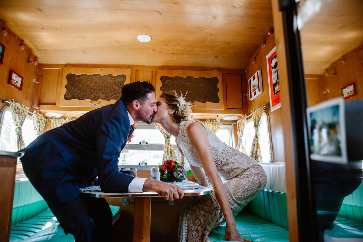 A couple leans in for a kiss inside.