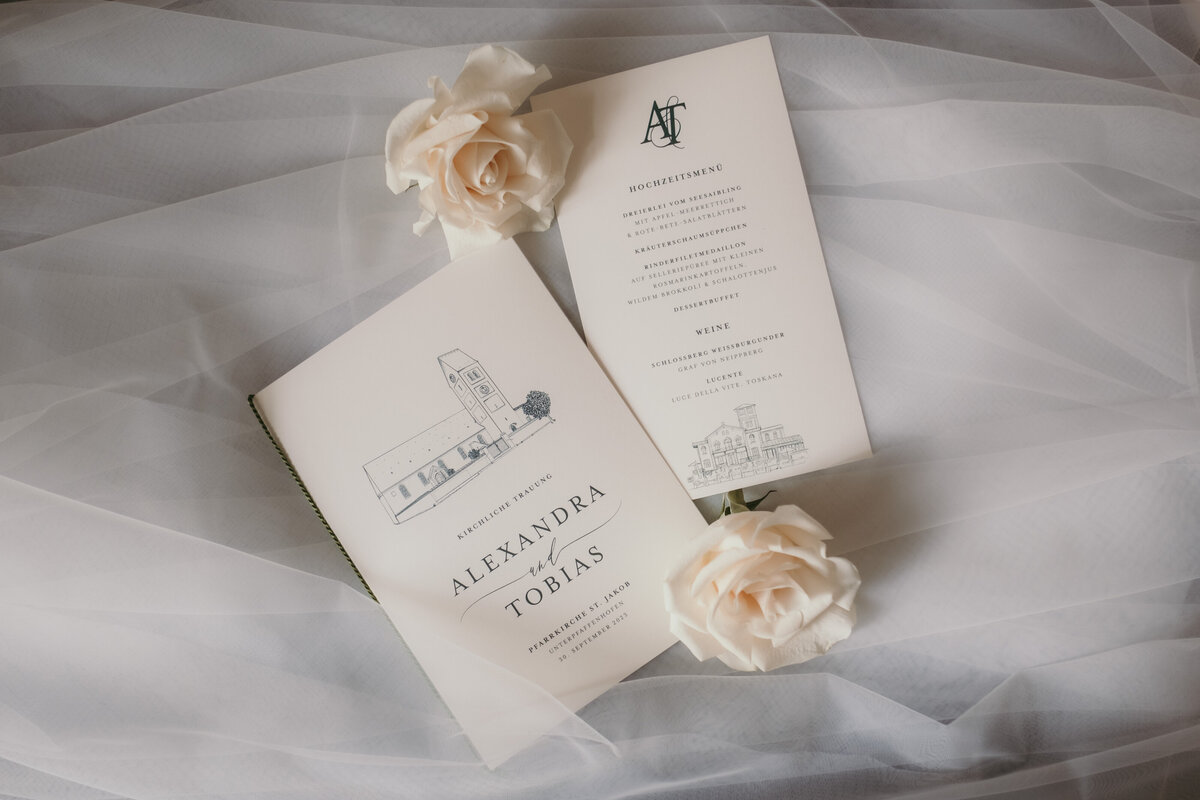 Detailshot of the wedding stationery laying on the brides' veil.