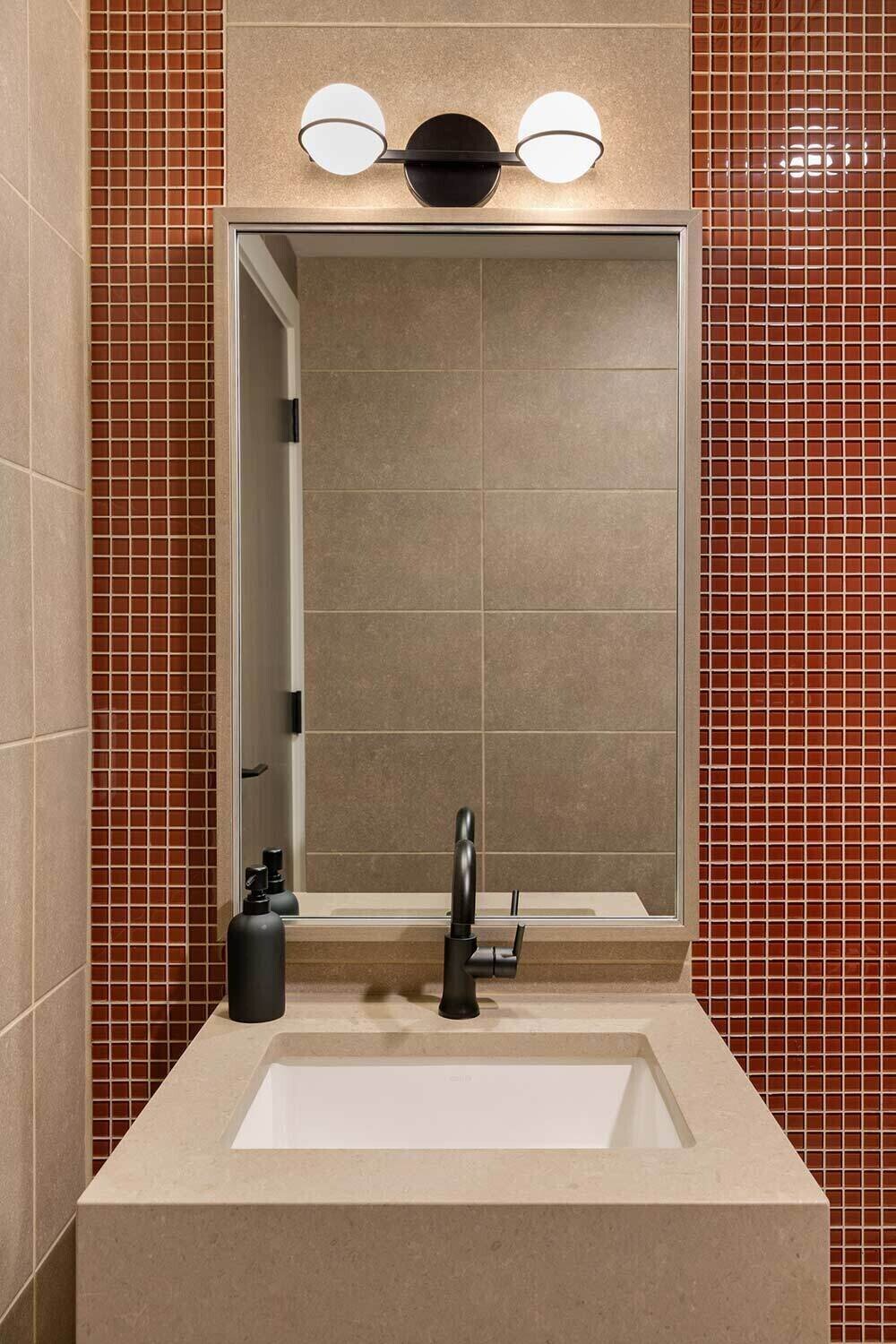 Detail shot of dental office bathroom with black fixtures and accent wall tile