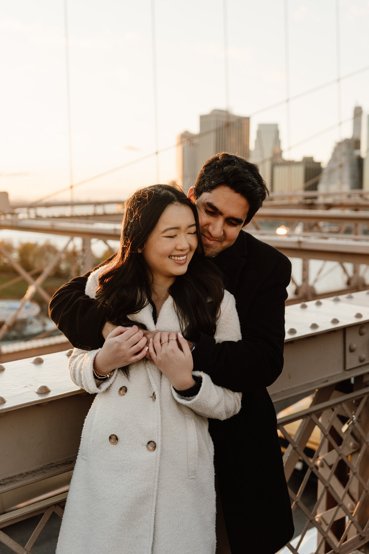 couple hugging on brooklyn bridge in new york