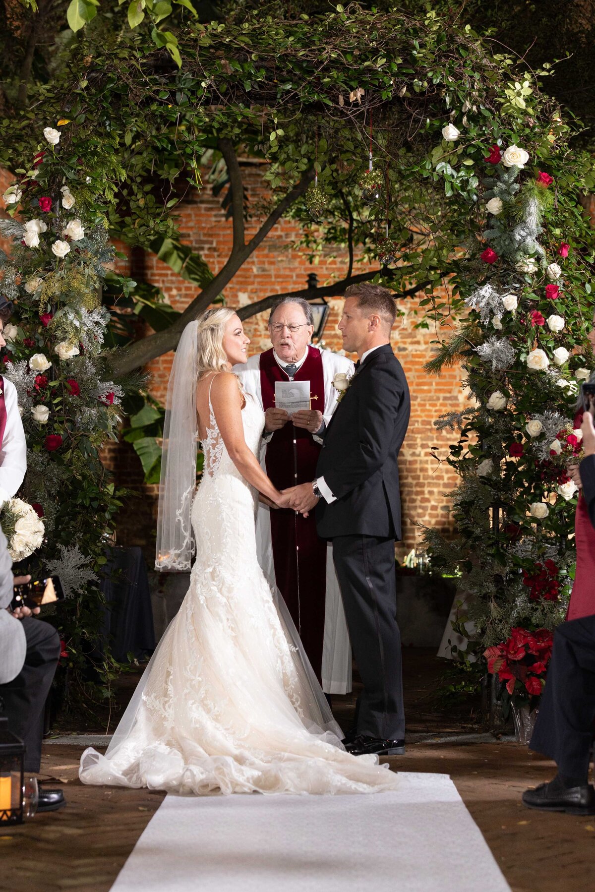 The couple exchanges vows during the wedding ceremony in the courtyard of the Pharmacy Museum in New Orleans, Louisiana.