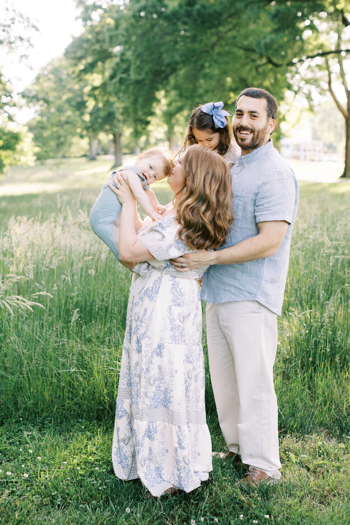 mom dad in kids in a field