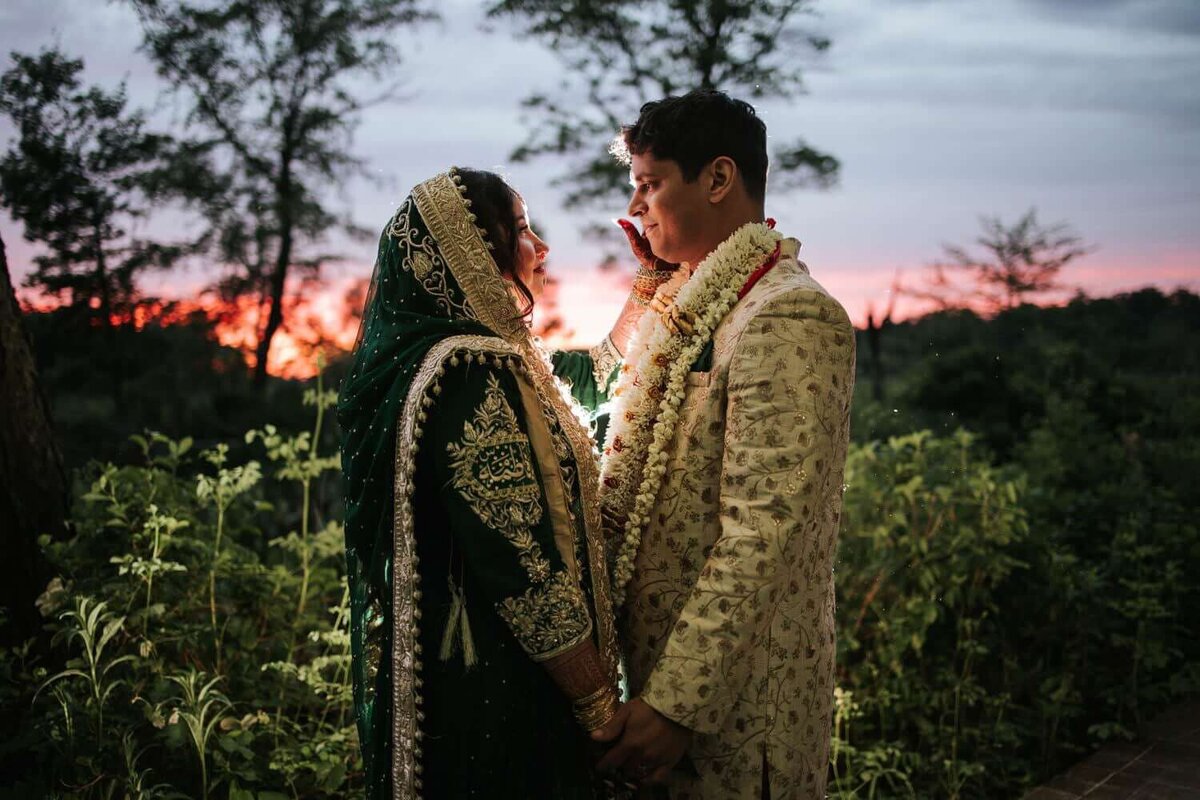 Bride and Groom holding hands and embracing. Just moments after thier Nikkah taking portraits under the warm pink sunset.