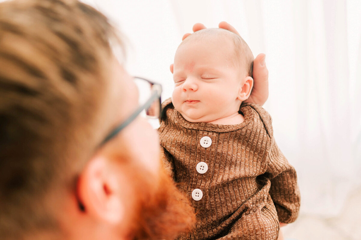 dad looking at newborn boy in Branson MO newborn photography studio