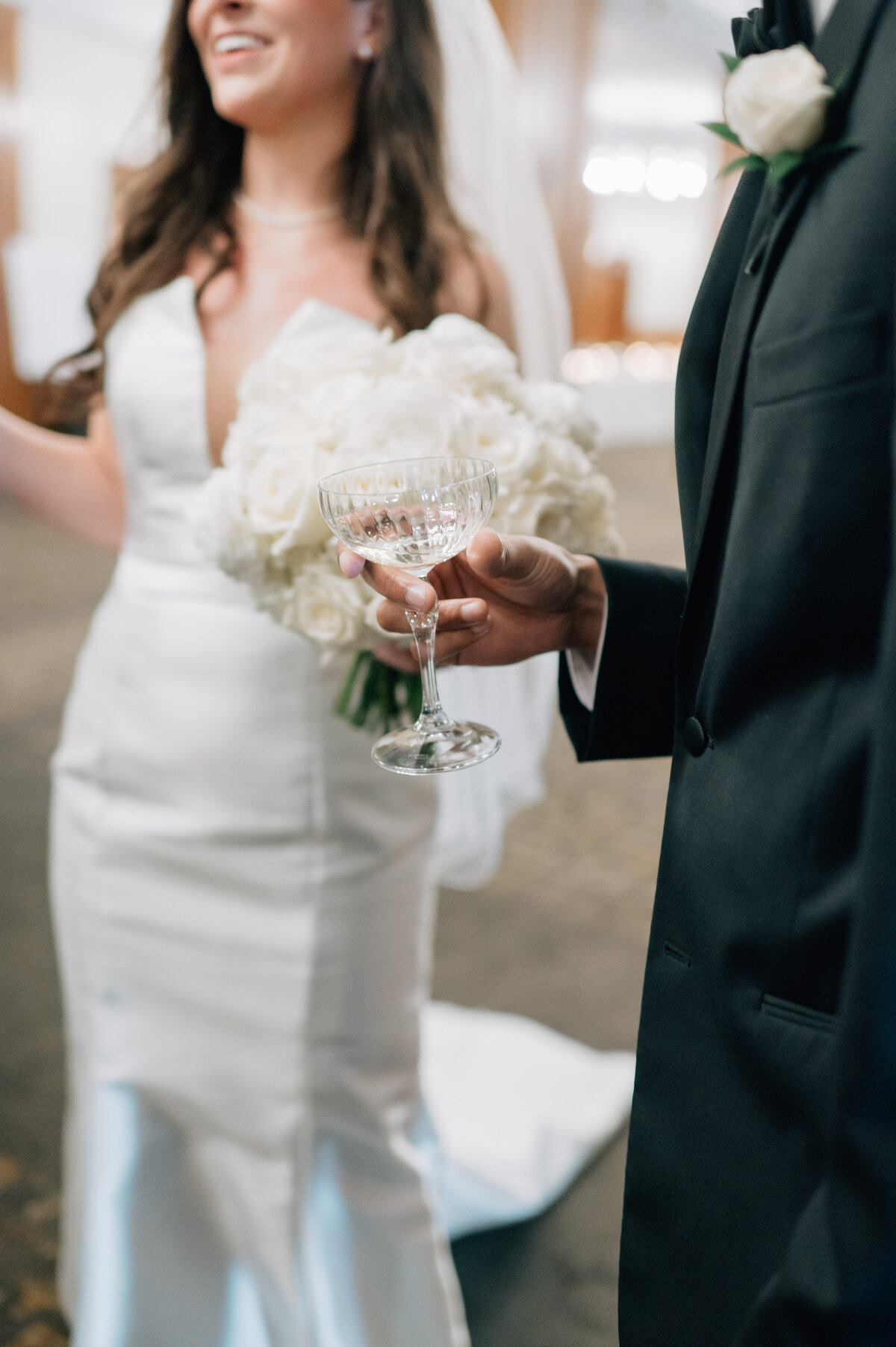 Bride and Groom talk and hold champagne glasses at their reception. Photo by Anna Brace, an Iowa Wedding photographer.