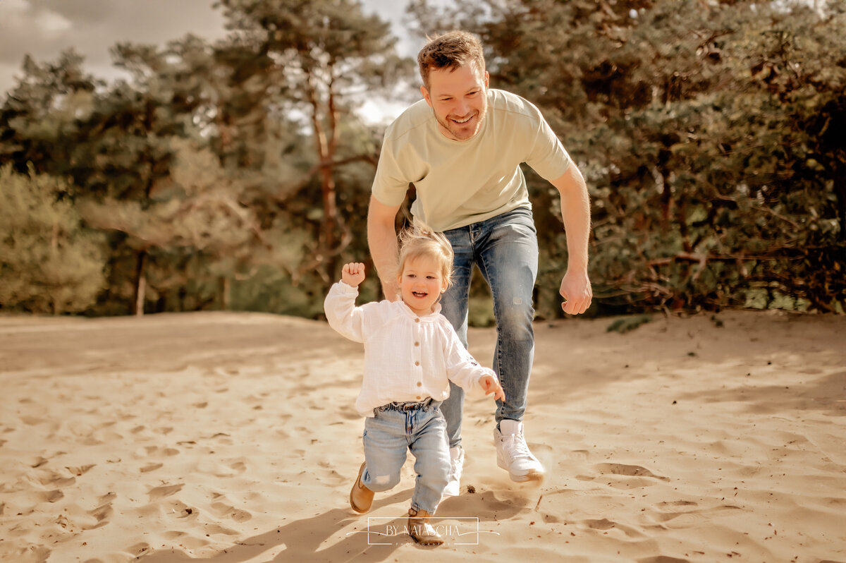 Dochtertje rent met haha achter haar aan in de duinen van Herperduin