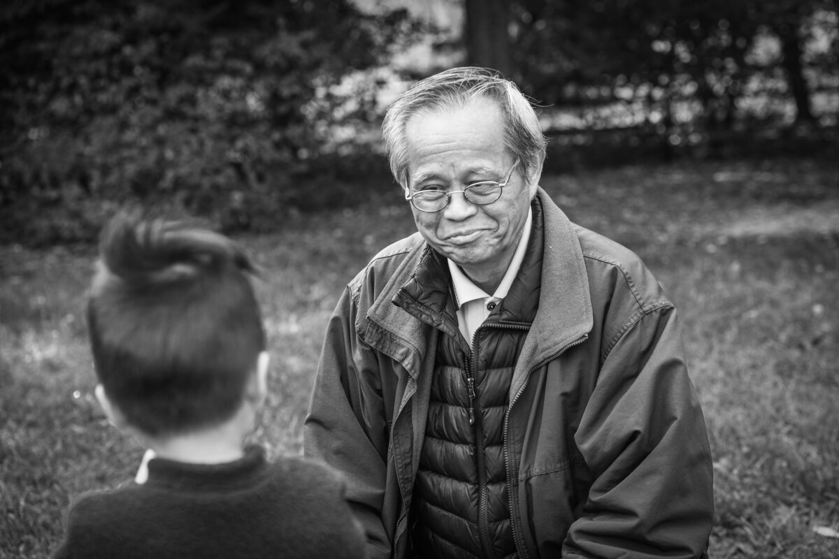 A grandparent smiling while looking at their grandchild