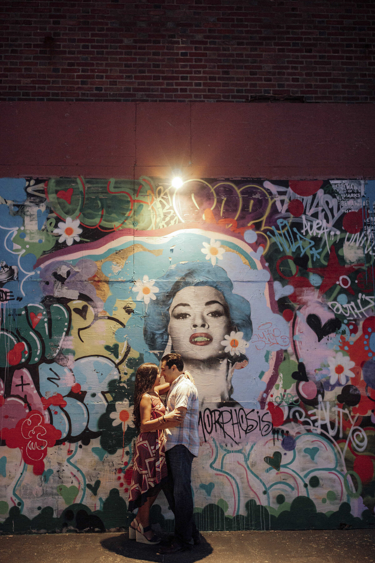 Couple posing by mural wall on building during engagement photos in Asbury Park New Jersey