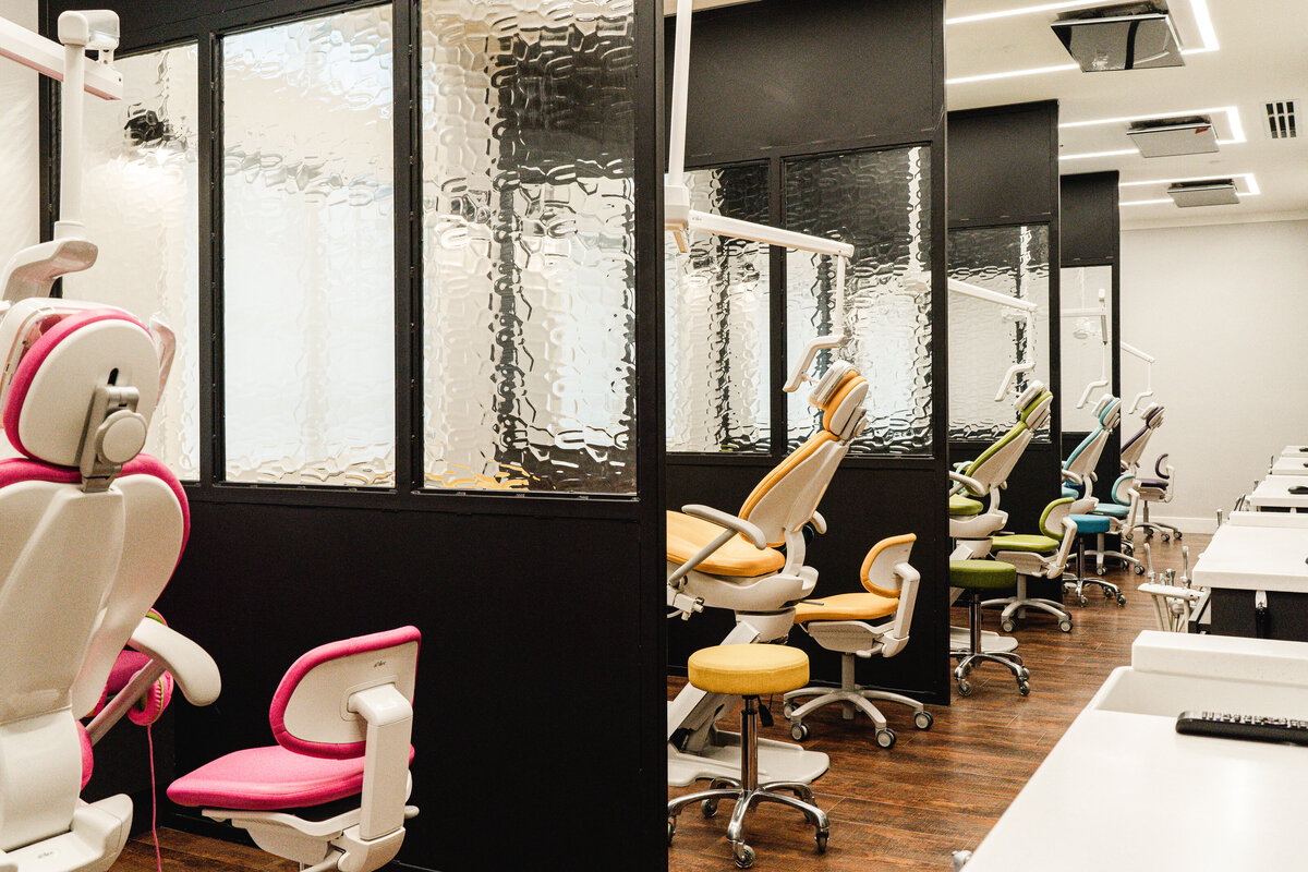 pediatric dentistry patient room with colorful chairs and glass room dividers