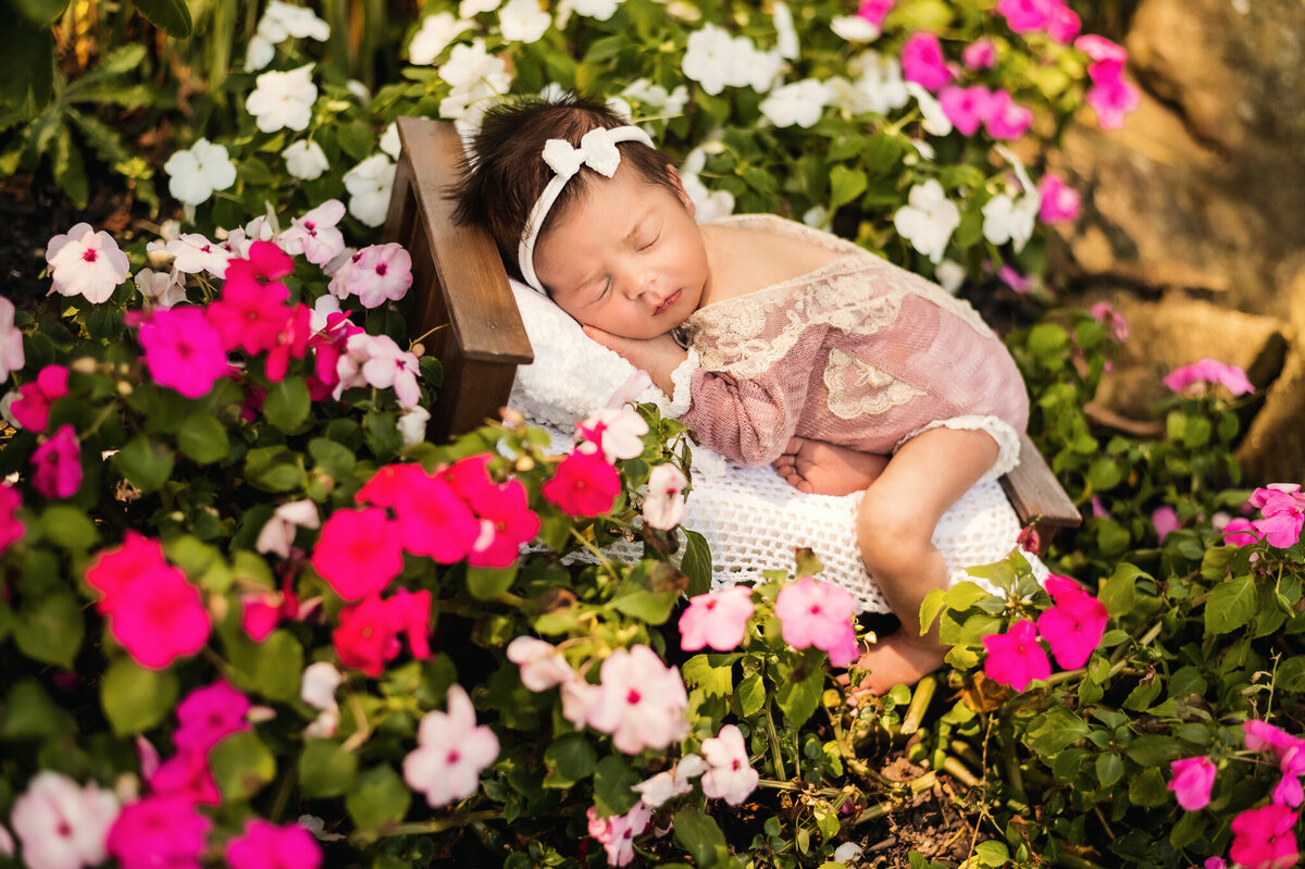 Infant baby asleep in flowers at her outdoor session near Beamsville, ON.