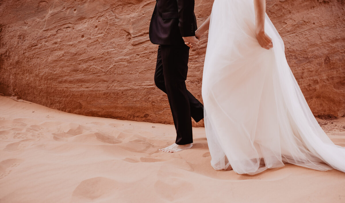 Utah elopement photographer captures bride and groom walking barefoot