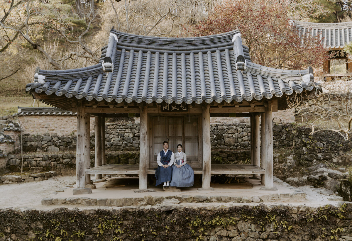 the couple sitting at a traditional korean house at soswaewon garden