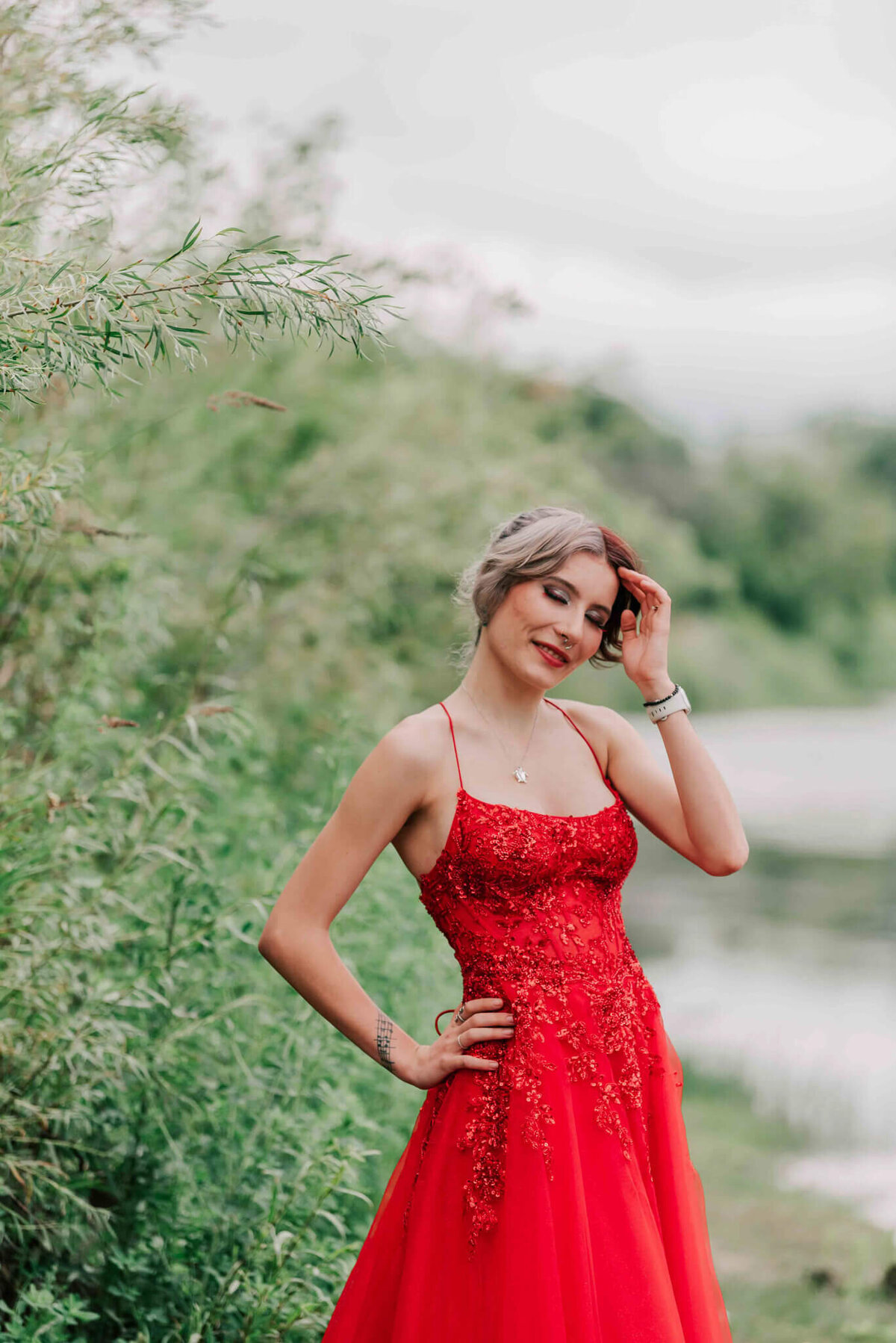 A beauty in a red dress  running her fingers through her hair.