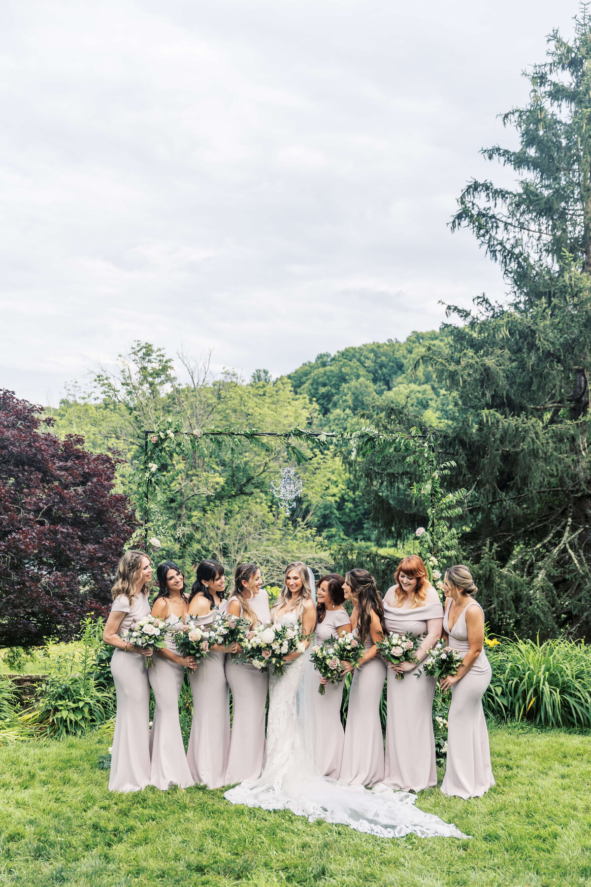 Bride laughs with her bridesmaids on her wedding day.