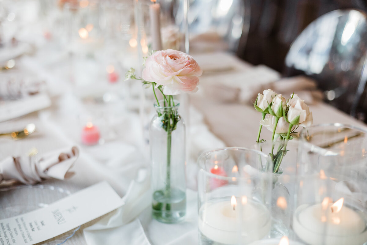 Elegant wedding table setting with pink and white floral centerpieces and candlelight in South Bend.