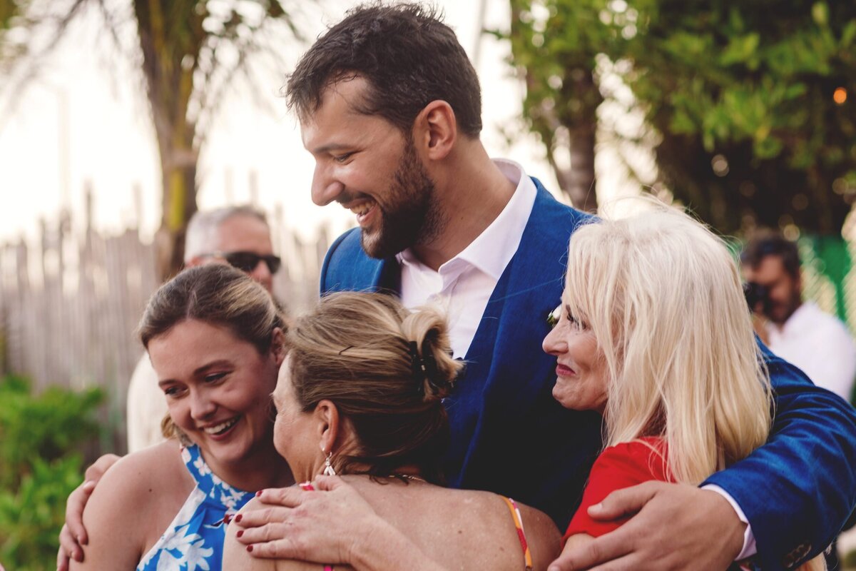 Groom getting hug from several guest at Blue Venado Seaside Riviera Maya wedding
