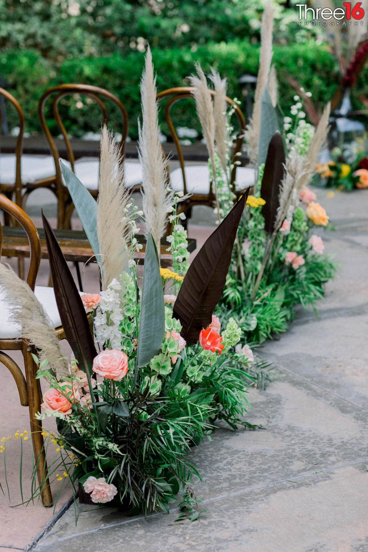 Amazing floral arraignments line the chairs at the wedding ceremony