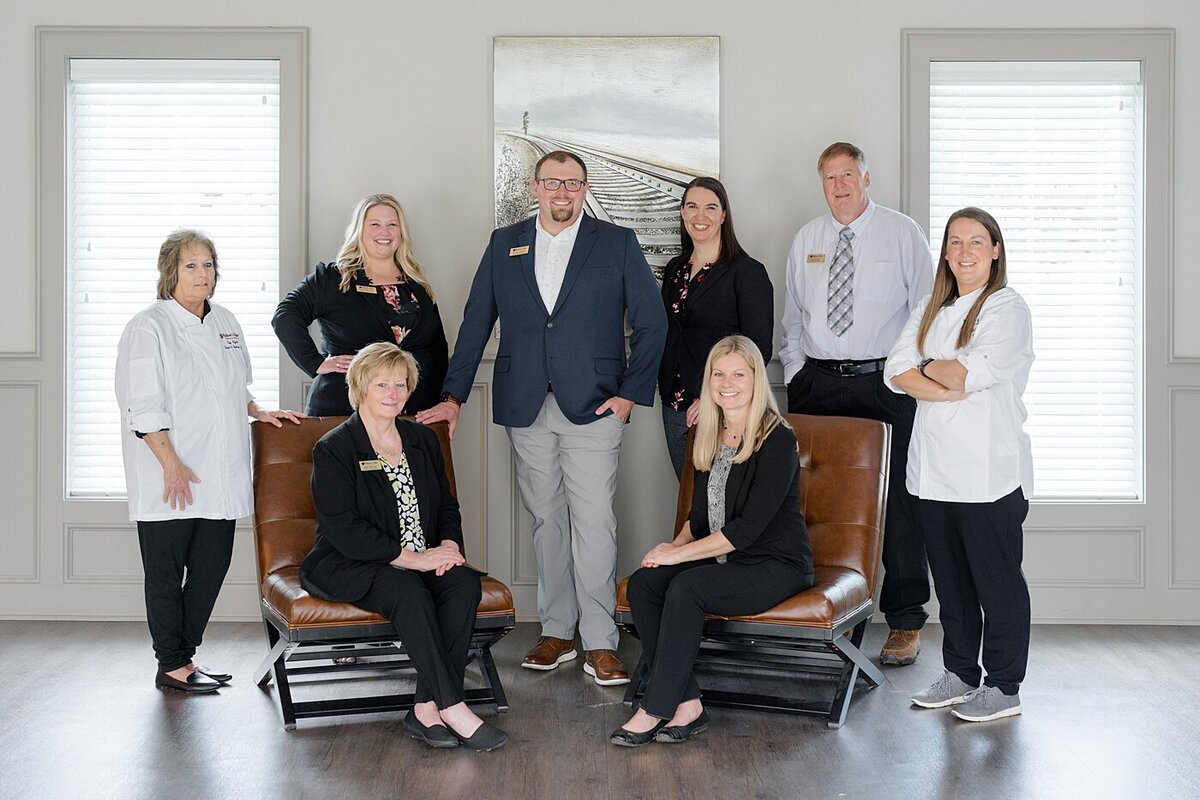team photo of office staff for branding photoshoot with some people sitting in chairs and others standing
