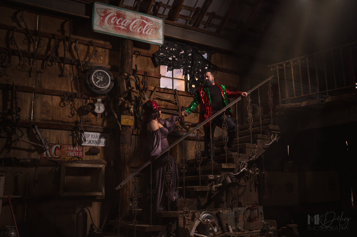 vintage couple nelsons ghost town on stairs coca cola sign purple dress  red and green sequined jacket by las vegas wedding photographers mkdelacy