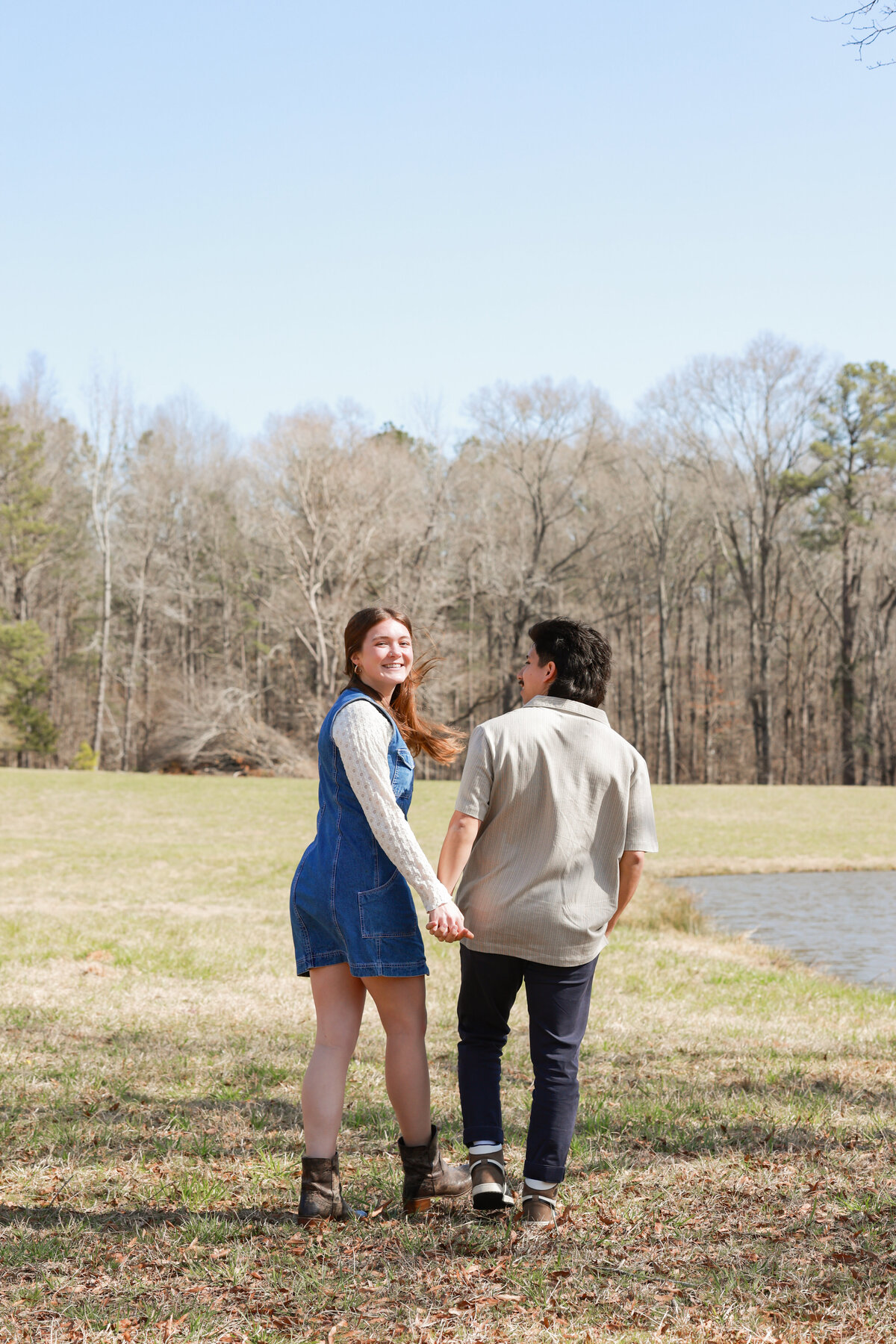 fiance holding hands and looking over shoulder in Columbus Georgia by Columbus Georgia engagement photographer Amanda Richardson Photography