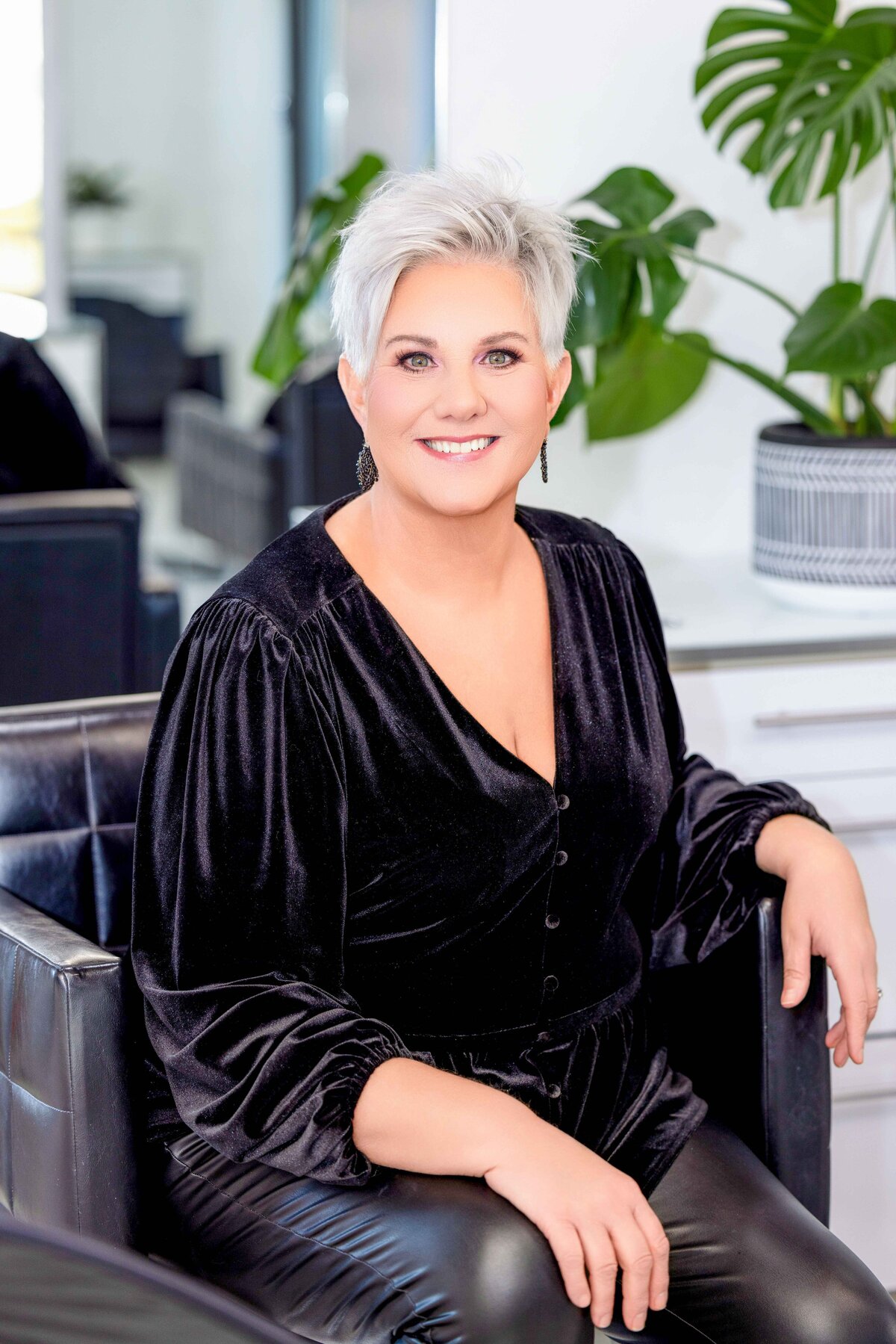 Entrepreneurial branding headshot of a woman with platinum blonde hair in a stylish salon setting.