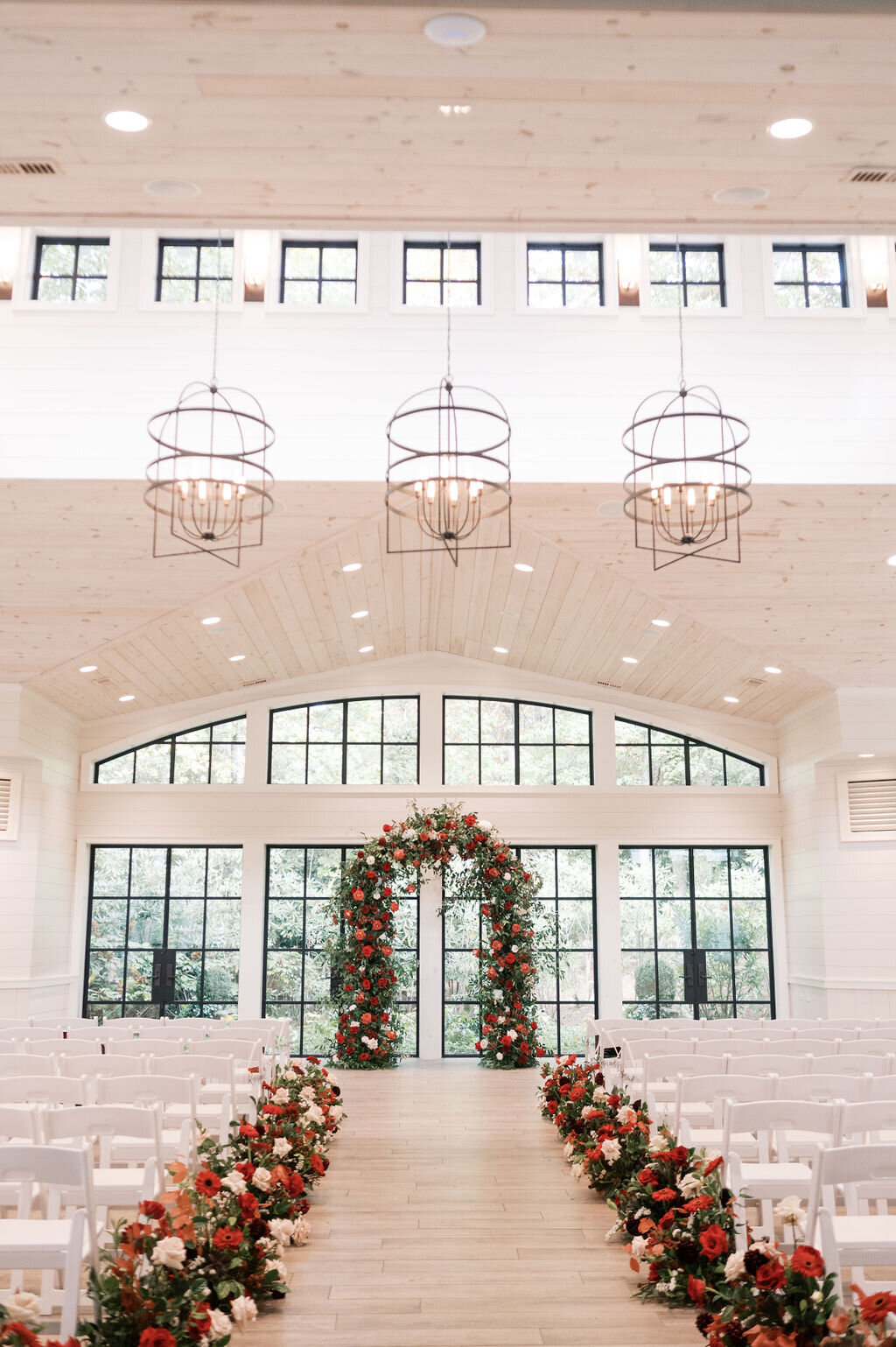 Lush red and blush floral aisle arrangements at indoor wedding ceremony at Old Edwards Inn in Highlands, NC.