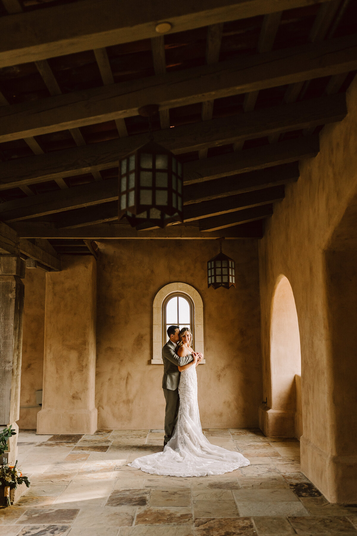 A groom hugging his bride from behind.