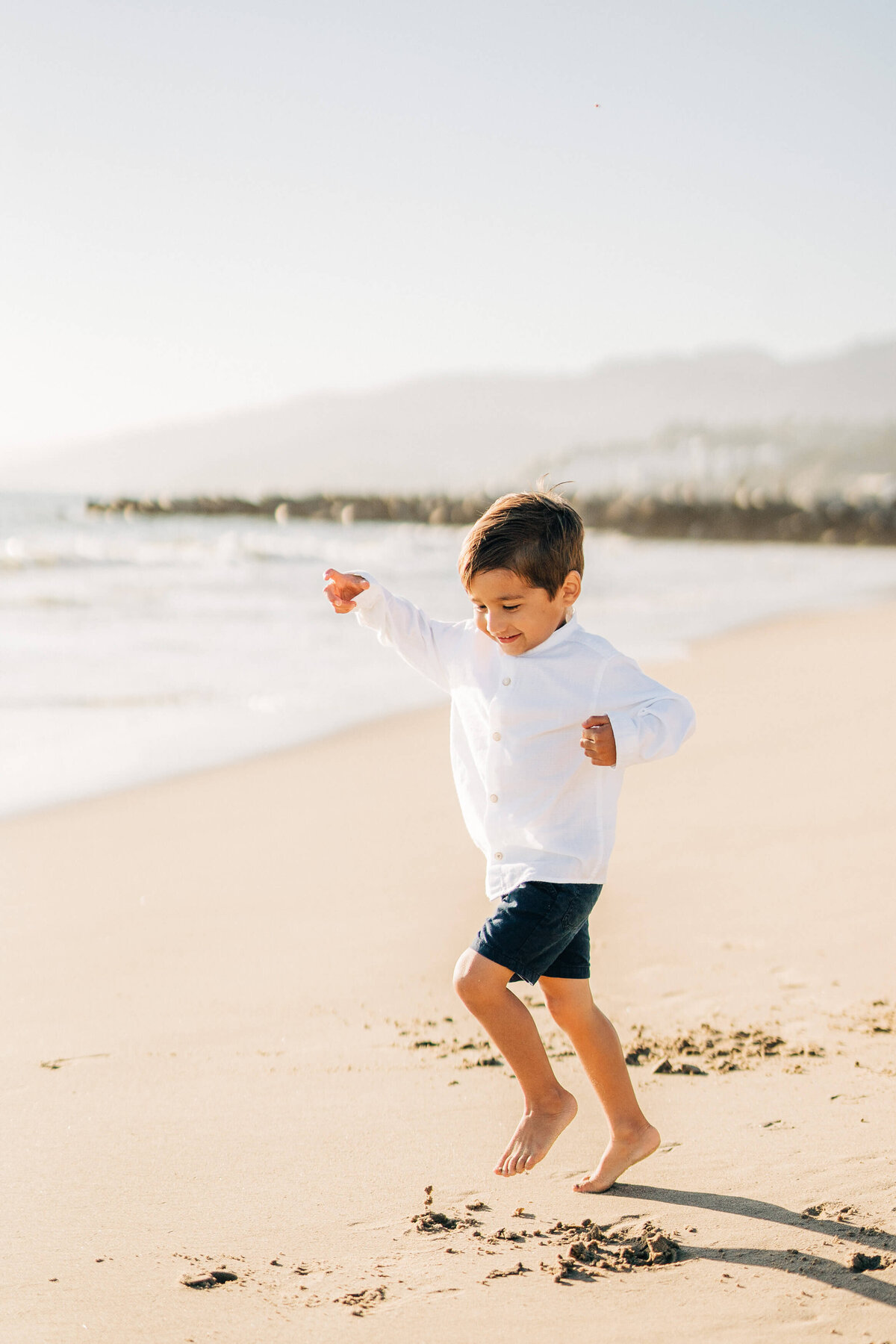 toddler jumping at the beach during their family photos in Los Angeles